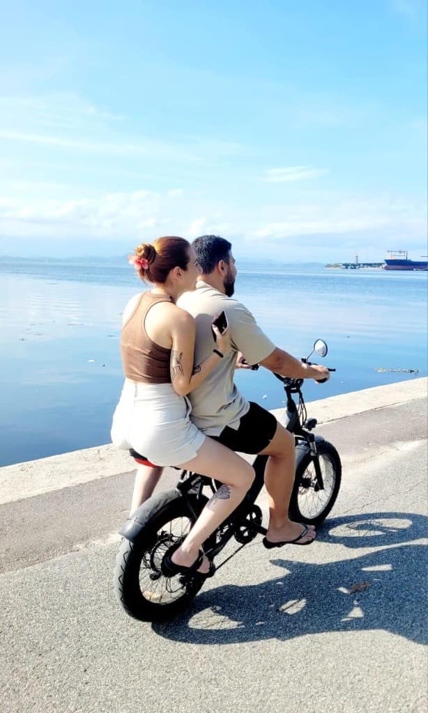 Mayra e Bruno de bike à beira da água