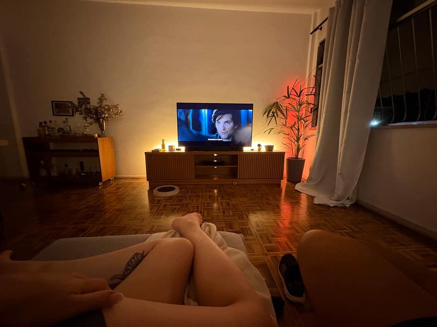 Mayra e Bruno assistindo filme, de pernas pra cima, no dia em que se mudaram